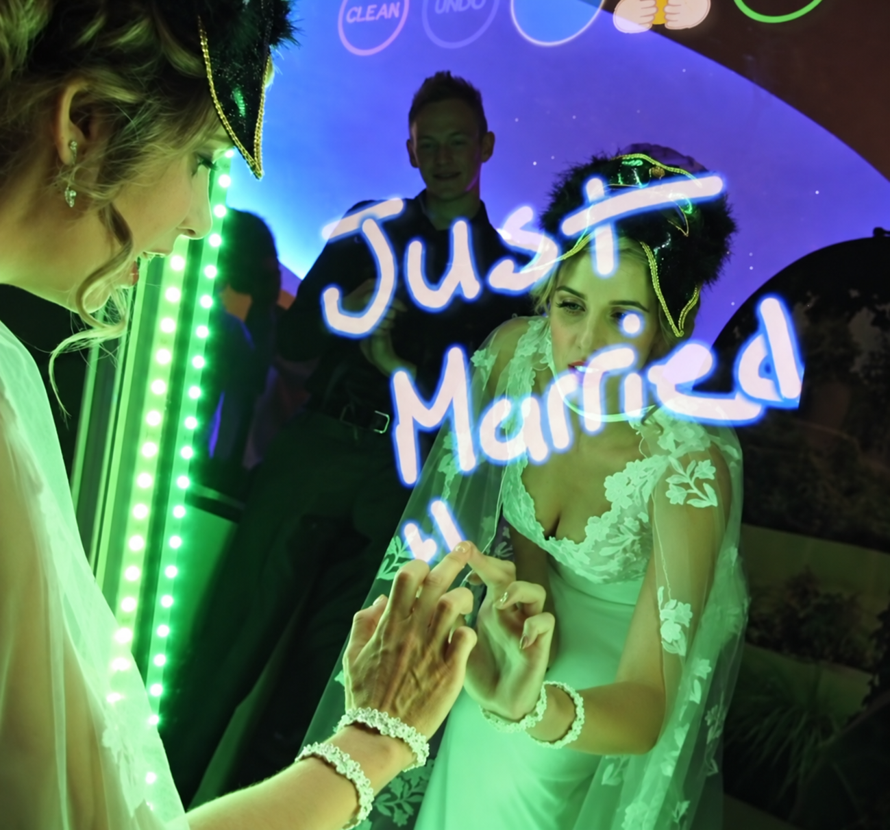A bride interacting with the illuminated mirror booth