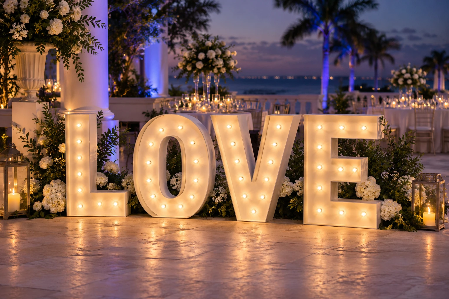 White freestanding LOVE marquee letters with warm bulbs at an evening wedding reception