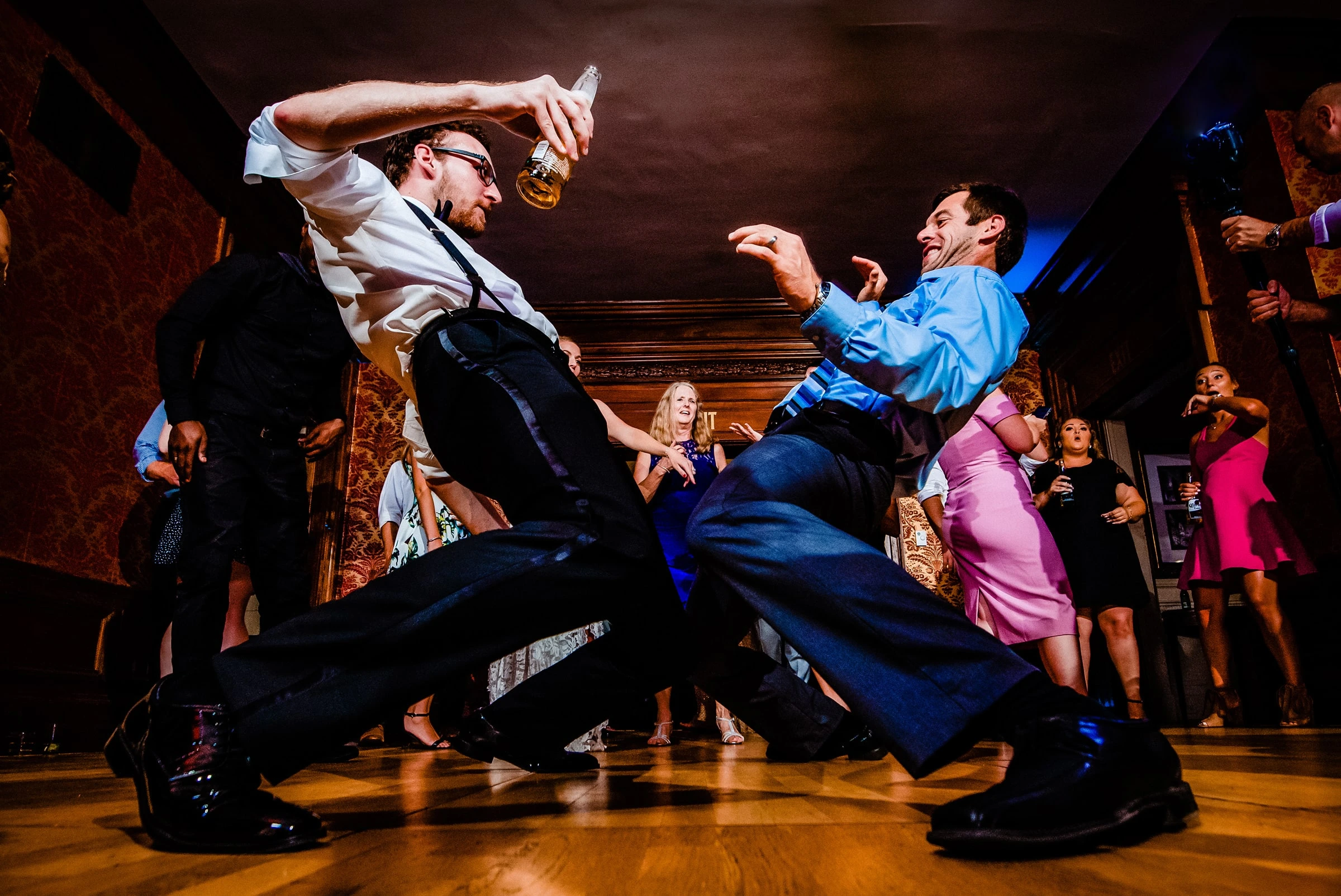 Two wedding guests dancing low to the floor