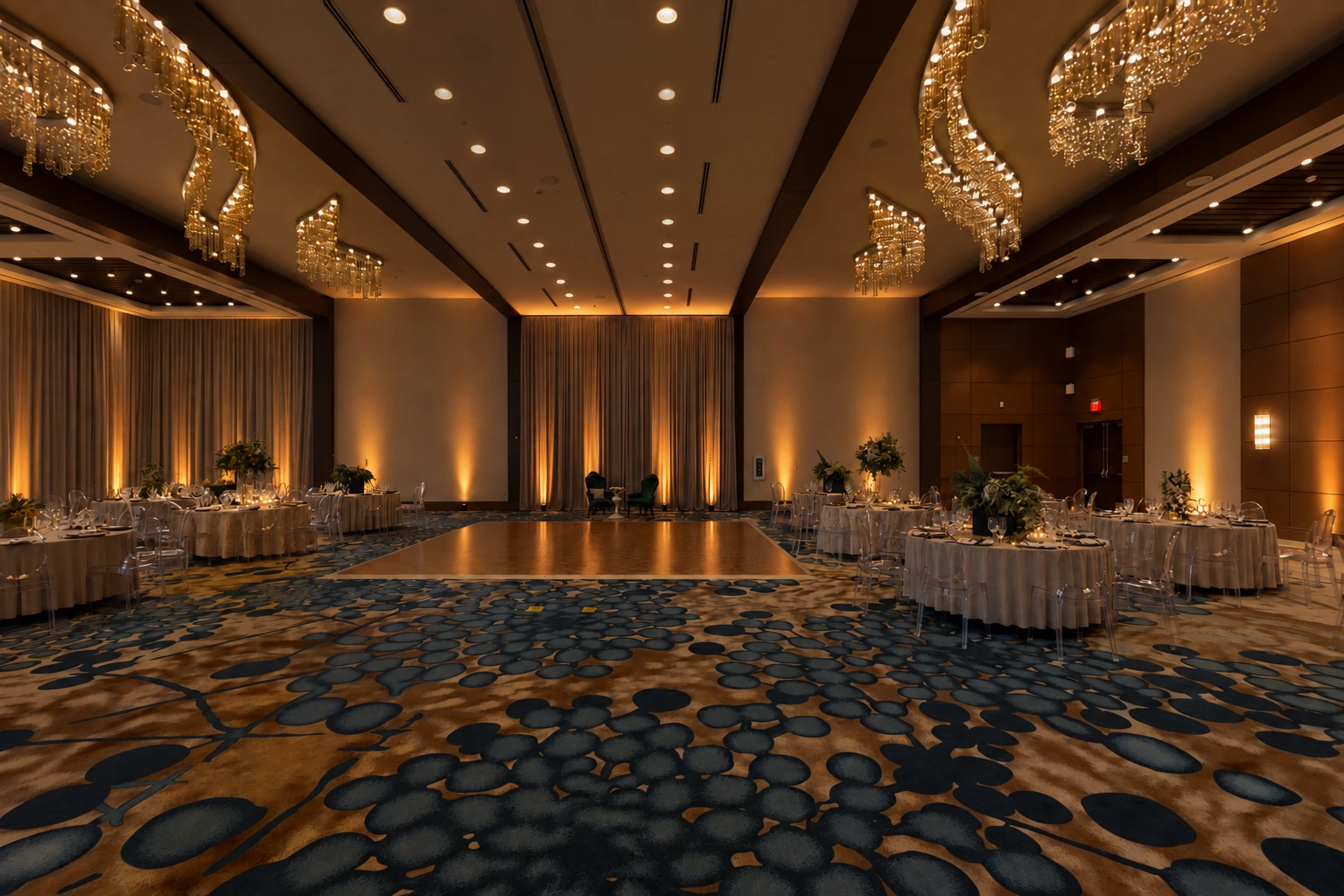 The ballroom with closed curtains, dimmed room lighting, and soft amber uplighting.